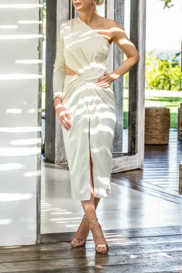 Luxury escort in Germany in an elegant white dress in a bright interior, Top Companions